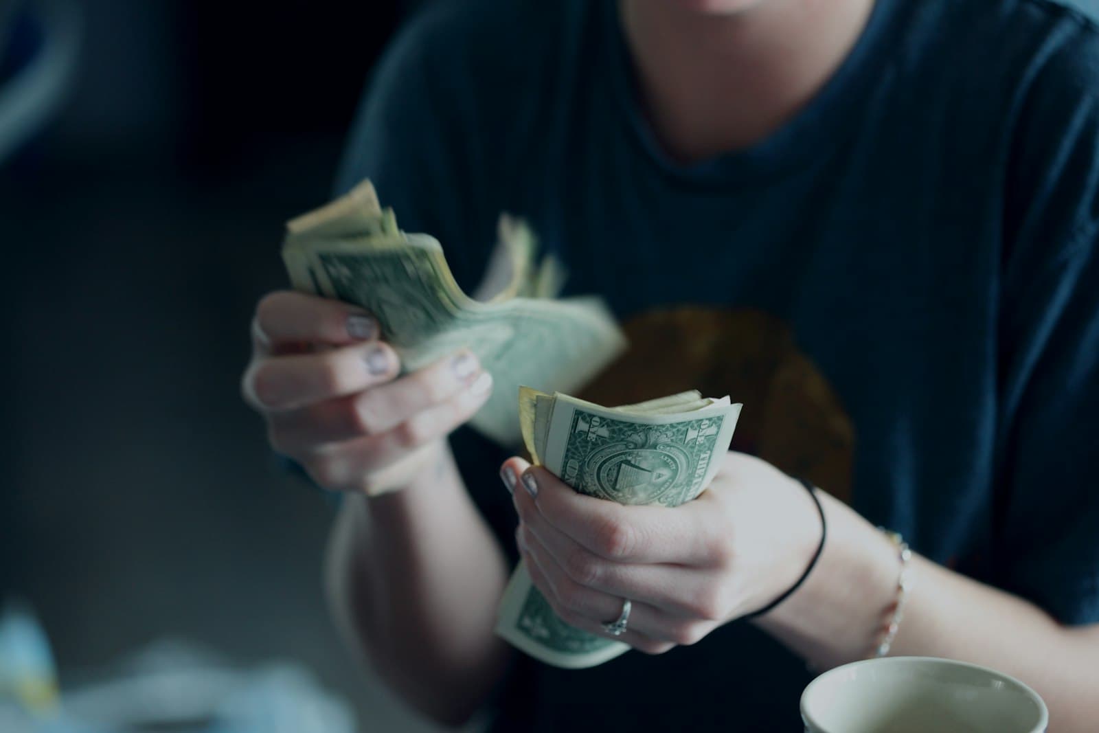 A pair of hands counting one-dollar bills
