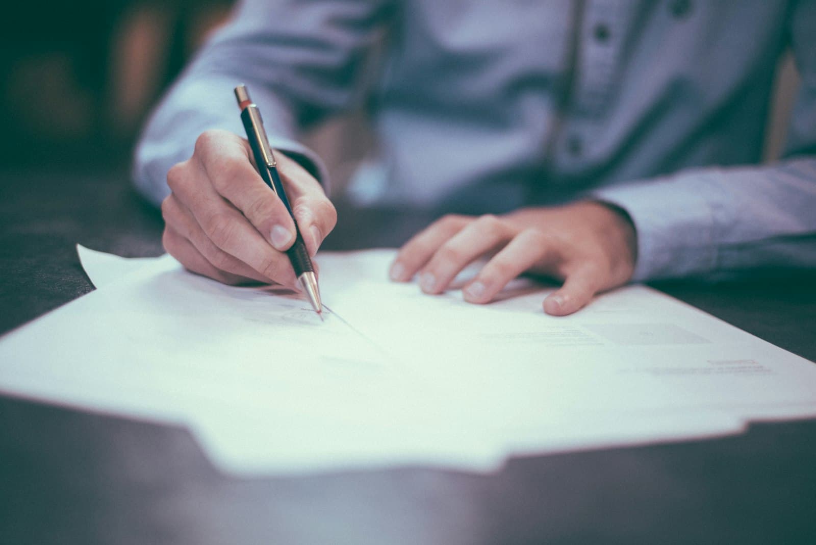 A person going over paperwork with a pen