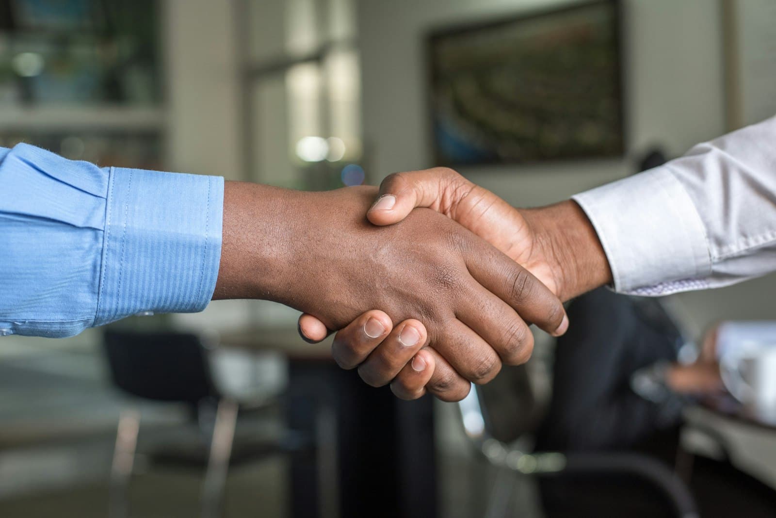 Two people shaking hands across a table