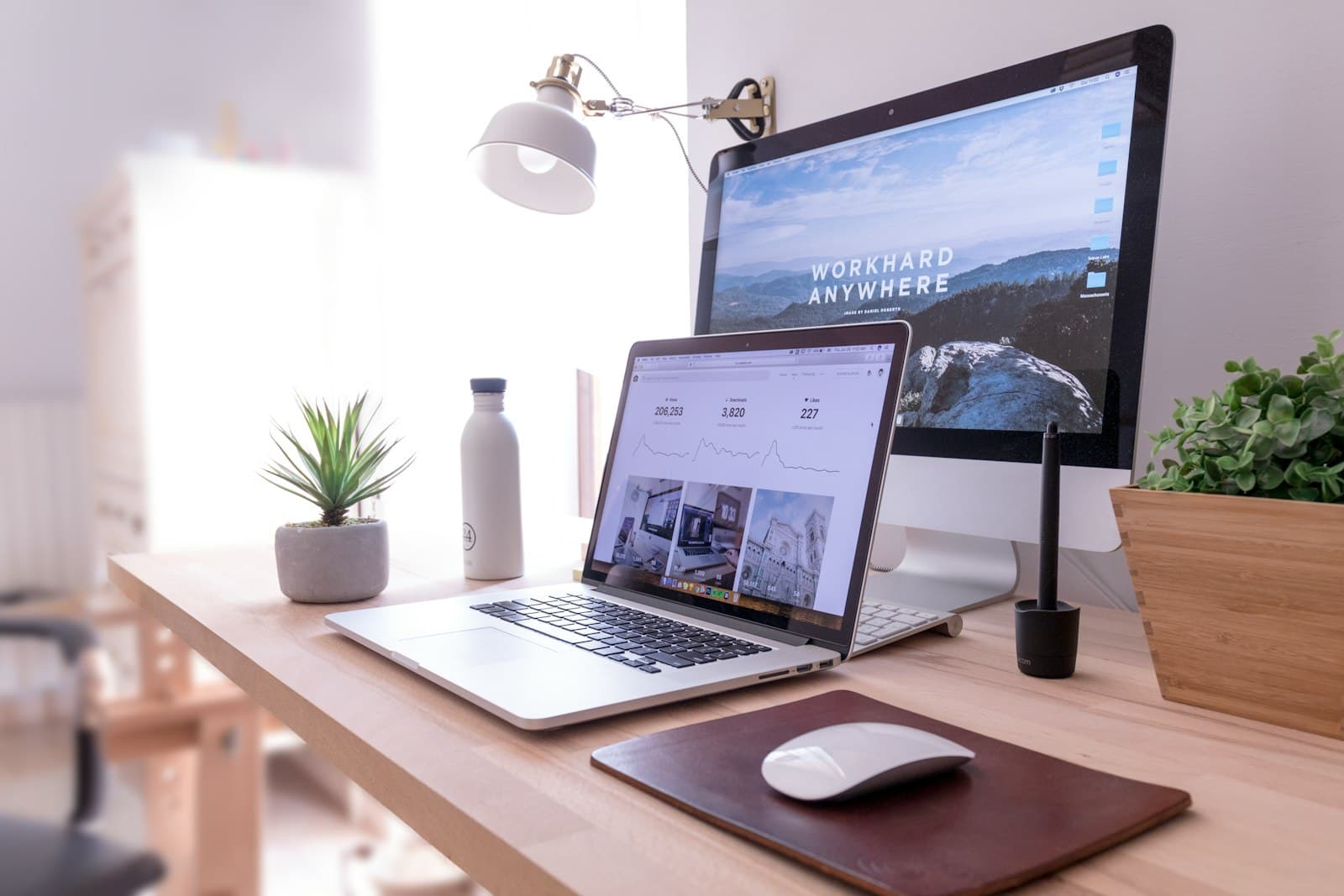A laptop and notebook set up on a small desk
