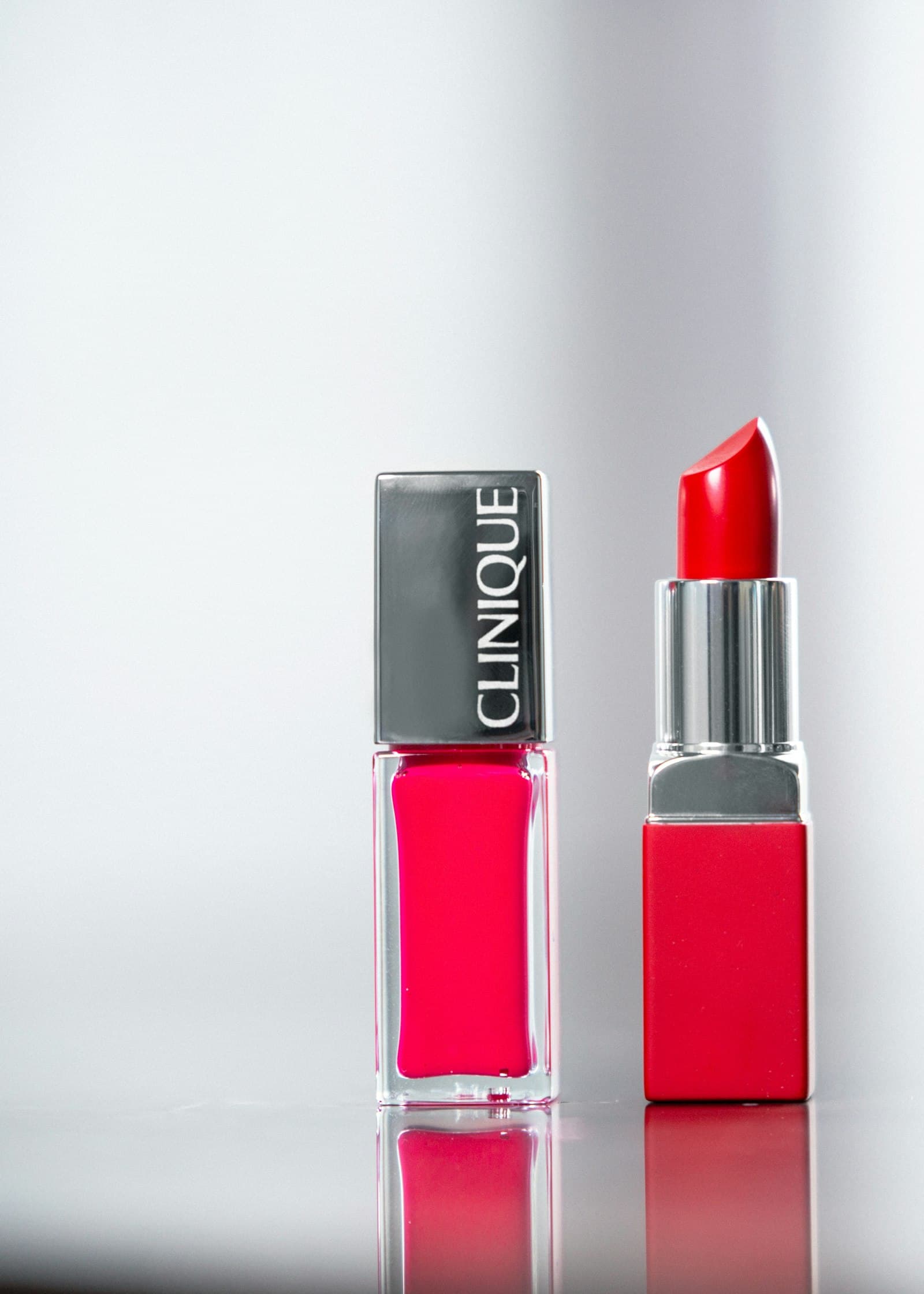 Two bright red lipsticks against a clean studio background